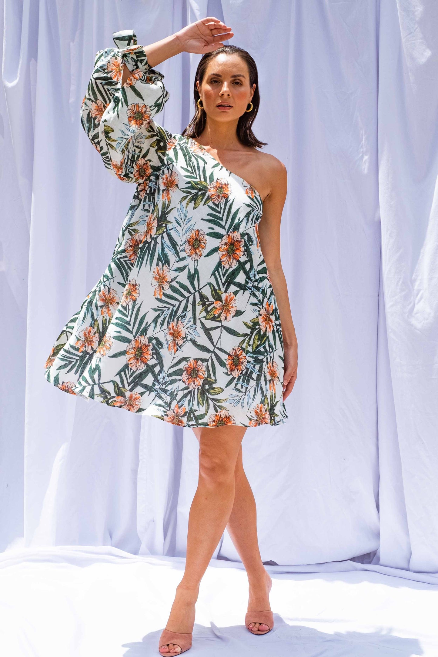 Woman wearing Palm Balloon Sleeve Swing Dress by Isabella Longginou. She is standing in front of a white background with one arm above her head.