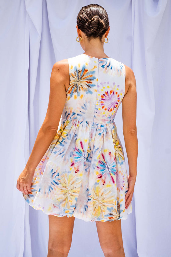 Woman wearing Tie Dye Bubble Mini Dress by Australian designer Isabella Longginou. The model has her back to the camera so the back of the dress is visible.